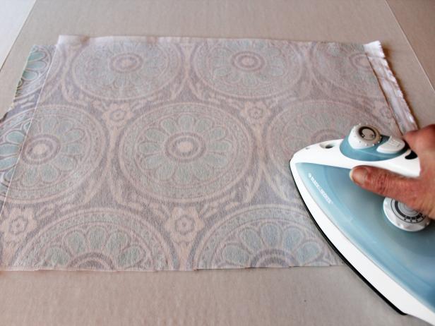 Cut a piece of fusible interfacing that's approximately the same size as your fabric. Layer the two, with the interfacing glue-side-down (has a shiny appearance) on the wrong side of the fabric. Press with a hot, dry iron to activate the glue, fusing the interfacing to the fabric (Image 1). Tip: The interfacing adds thickness and strength to the fabric, making it much easier to attach to the cardboard without having to worry about wrinkles or the fabric fraying.
