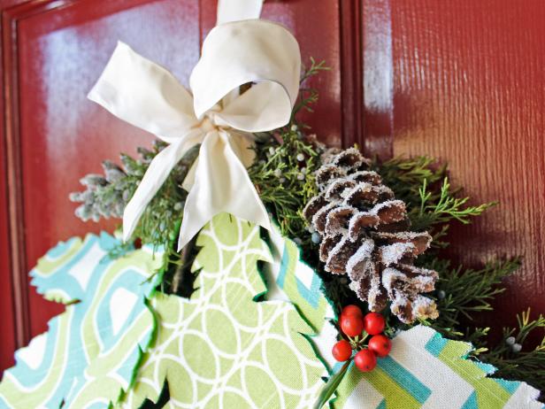 Wrap the third piece of copper wire around the bundled branches just once then create a hook for hanging the finished swag from a nail or knocker on your front door. Finally, add a fabric bow to cover the wrapped wire and and attach the glittered pinecones