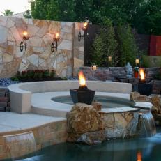 Outdoor Spa and Pool With Stone Wall and Waterfall Feature