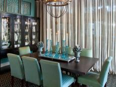 A formal entertaining space infused with mocha and sea-blue hues, the dining room opens out to the back deck, with boundaries defined by sheer linen drapes rather than solid walls.