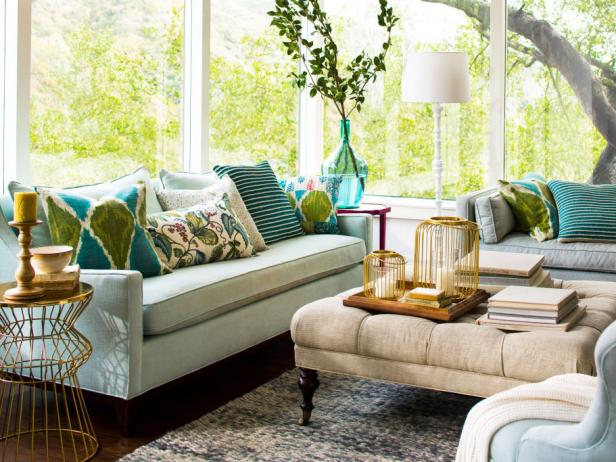 The soft shades of blue, green and beige used throughout this living room blend seamlessly with the serene outside view. Your eye easily takes in both the interior design choices and the beauty beyond all the windows because they don't compete.