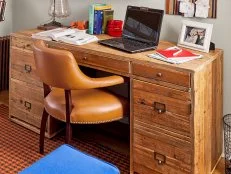 Pine desk with office supplies, laptop, and textbooks. 