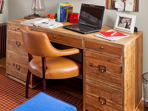 Pine desk with office supplies, laptop, and textbooks. 