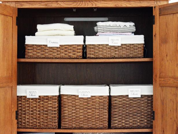 Wicker baskets full on linen's in a closet. 