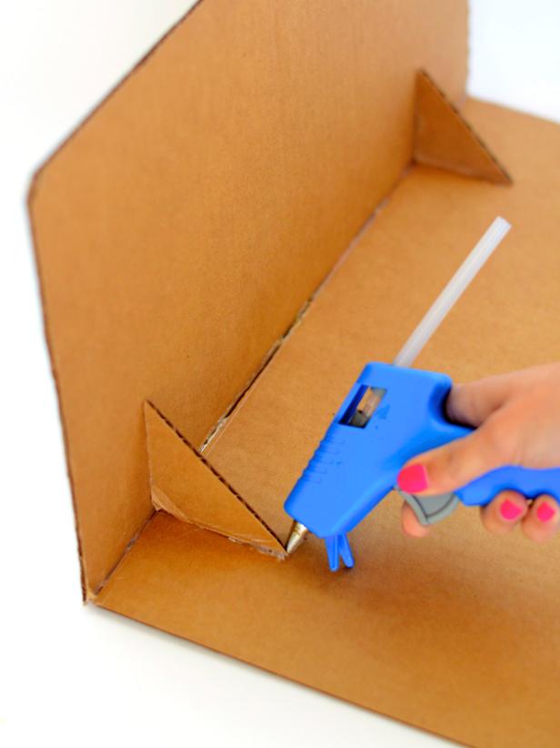 Use hot glue gun to create a right angle out of two cut cardboard flaps. Once dry, glue cut cardboard corners into inner corner of right angle as pictured.