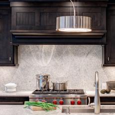 Transitional Kitchen With Dark Wood Cabinets and Granite Backsplash