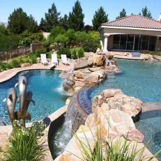 Multi-Level Pool Area With Dolphin Sculpture, Stone Accents, and Water Feature