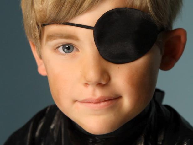 To apply pirate makeup, begin by &quot;dirtying up&quot; the face by using a sponge to smudge brown and yellow eye shadow on child's cheeks, forehead and down the neck. Darken the eyebrows using eye shadow and/or eyeliner pencil, making them look as full and unkempt as possible. Tip: The darker the color and more severe the arch, the more menacing your pirate will look. Add an eye patch. On the eye that is not covered, add dark brown eye shadow underneath to mimic dark circles and collected dirt from endless pillaging and those long months at sea.