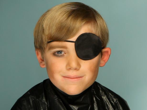 To apply pirate makeup, begin by &quot;dirtying up&quot; the face by using a sponge to smudge brown and yellow eye shadow on child's cheeks, forehead and down the neck. Darken the eyebrows using eye shadow and/or eyeliner pencil, making them look as full and unkempt as possible. Tip: The darker the color and more severe the arch, the more menacing your pirate will look. Add an eye patch. On the eye that is not covered, add dark brown eye shadow underneath to mimic dark circles and collected dirt from endless pillaging and those long months at sea.