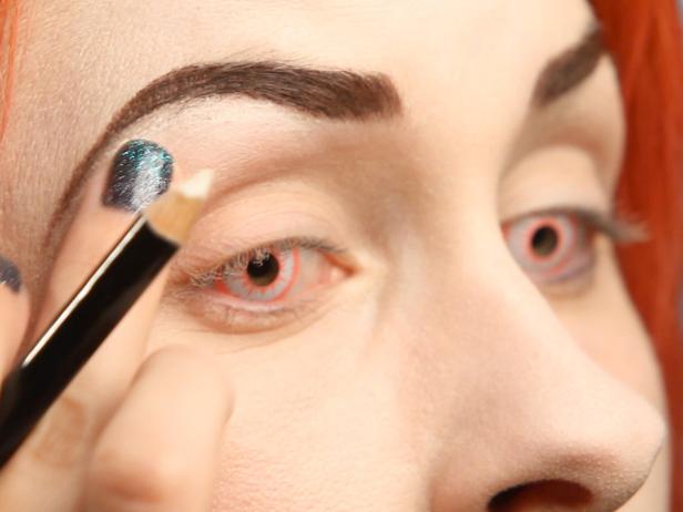 Define directly under your brow bone with a white pencil liner. Blend it smooth with your finger.
