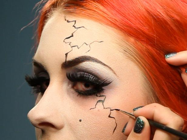 Take a liquid eyeliner with a very thin tip and draw on squiggly cracks and veins coming down from the hairline at the forehead, down into the eyebrow, out from under one eye and at the sides of the cheeks. Add more down the chin and neck, on your clavicle and anywhere skin is showing.