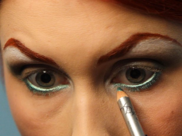 Line your waterline, which is the inside of your eyelid, with a shimmering green pencil liner. Extend the color even below the waterline onto your lash line, and make sure the green is vibrant.