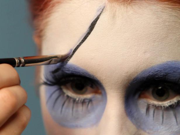 If you used cream makeup, set it with powder before moving on. Shade these lines using blue eye shadow.