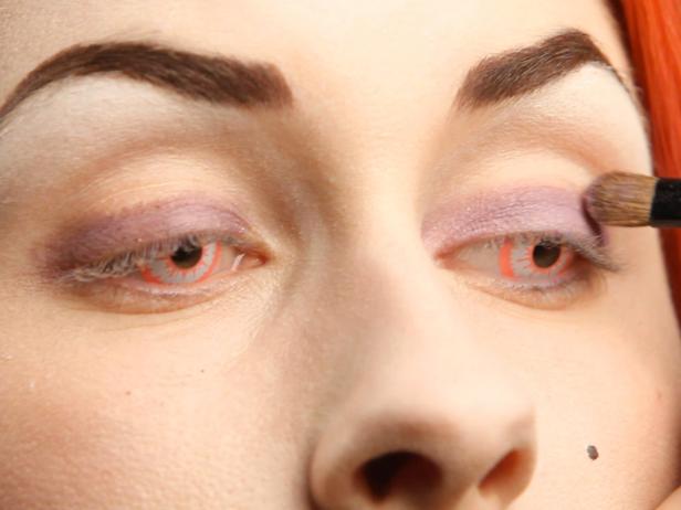 Apply dark purple eye shadow at the base of the eyelid, then gradually blend up with light purple eye shadow extending all the way up to the brow bone. Continue the dark purple shadow all the way around the eyes.