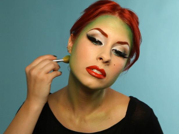 Begin to blend green eyeshadow around the edges of your face and in your cheek contour. Blend 2 to 3 shades of green in a gradient starting at your hairline, and working outward. Choose a deep forest green shade, a Kelly green and a lime shade; at least one of your shadows should have shimmer in it.
