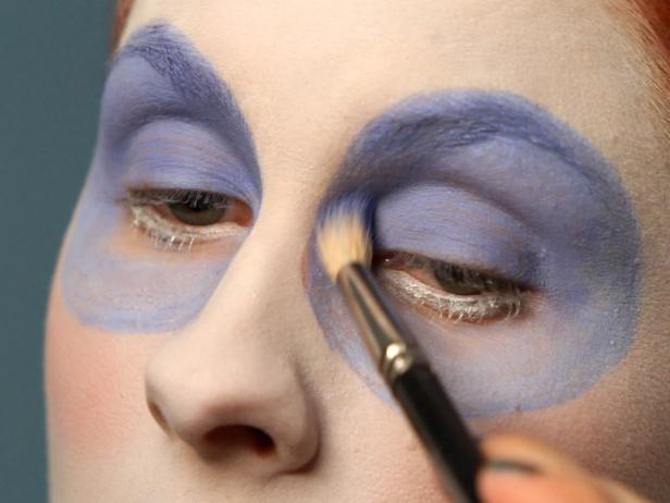 Cover circles with blue eye shadow in a similar color. Use a slightly darker blue eye shadow for the top part of the circle and eyelid and a slightly lighter blue eyeshadow for the lower half of the circle to create a very subtle fade. These circles will help give eyes the illusion of being extremely large.