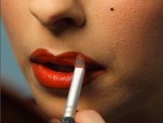 Woman Applying Red Lipstick for Halloween Makeup