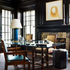 Glass-Topped Desk in Black Wood-Paneled Home Office