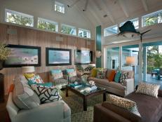 Family Room With Colorful Accent Pillows, TV Screens and Large Windows 