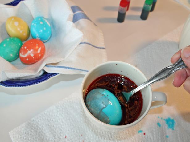 Rolling dyed Easter egg in ollive oil to marbleize it