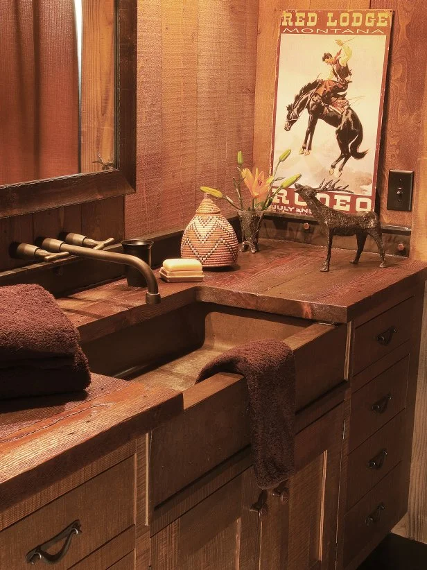The bathroom sink offers custom cabinetry made from recycled materials and a hammered copper sink. Western artifacts complement the setting.