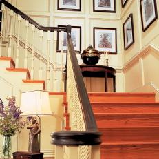 Traditional Staircase with Decorative Landing and Framed Art