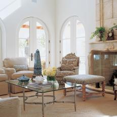 Mediterranean Living Room With Arched Windows and Stone Fireplace