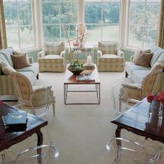 Bright Transitional Sitting Room Features Ghost Chairs