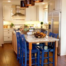 White Kitchen With Spacious Island and Blue Chairs