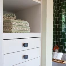 White Bathroom Storage Shelves Behind Green Shower 