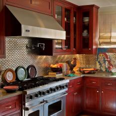 Kitchen with Stainless Steel Tile Backsplash and Warm Red Cabinets