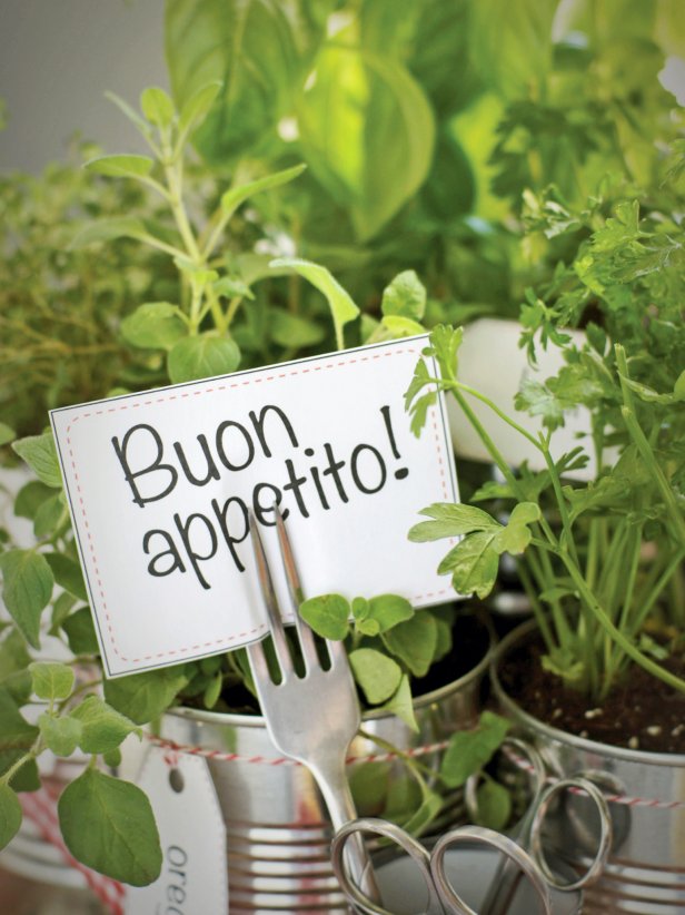 Add the smallest can to the front center, and use it to keep small scissors handy for snipping herbs. Wrap a length of ribbon around all the cans and tie together to secure. Print then cut out the plant labels and tie each around its respective can with twine or string. Finally, slide the printed greeting through the tines of an old fork.