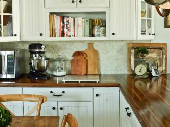 White cottage kitchen, with butcher block countertops and bronze knobs