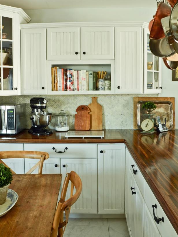 White cottage kitchen, with butcher block countertops and bronze knobs