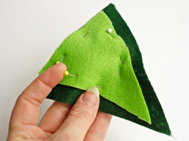 Make a second template half an inch smaller in width and height. Trace smaller triangle template onto light green felt with chalk pencil. Cut and pin the pieces together.