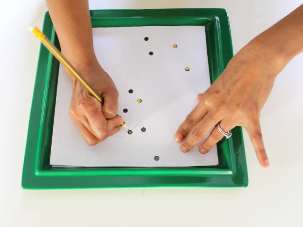 Tracing a printable constellation onto a plate with carbon paper.