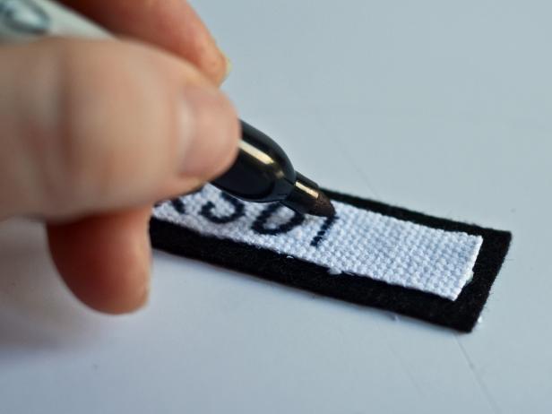 Glue the two pieces together with fabric glue then write child's last name on twill tape with a permanent black marker.