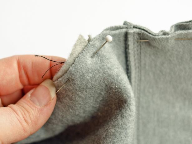 Insert fin into cut slit and pin seam from inside of hoodie.