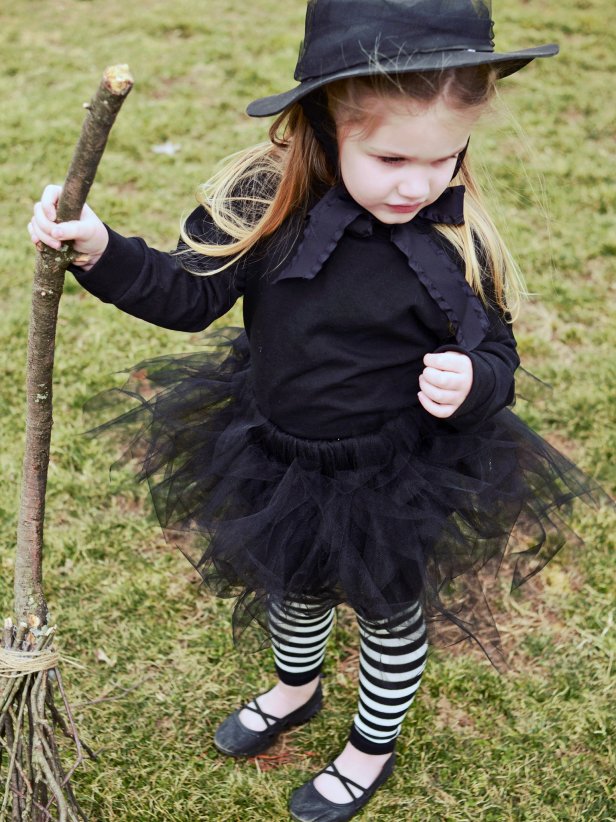 A no-sew tutu, pointy craft-foam hat, DIY broom and striped tights are paired with a black T-shirt for a wee witch's costume that's cute enough to cast a spell on even the biggest Halloween humbugs.