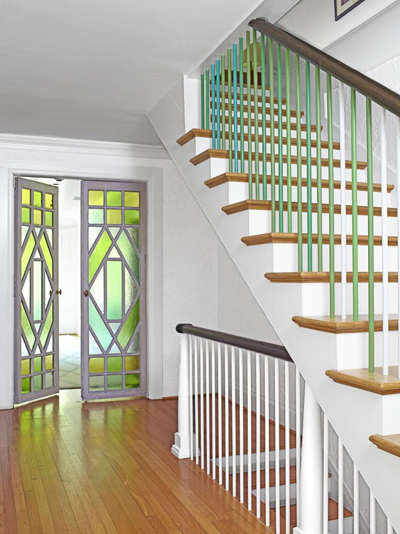 Hallway with repurposed stained glass doors and painted railings. 