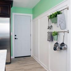 Cottage Kitchen With White Wall Paneling and Hanging Rack