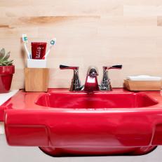Red Bathroom Sink With Pale Wood Backsplash