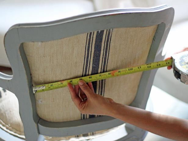 Using a tape measure to measure the back of a chair. 