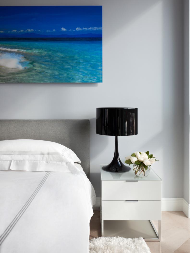 White Bedroom With Ocean Art and Modern Black Lamp 