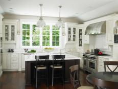 Designer Christine Donner creates a sophisticated kitchen design that features pro-quality appliances, an oversized island and contrasting white and dark cabinetry.