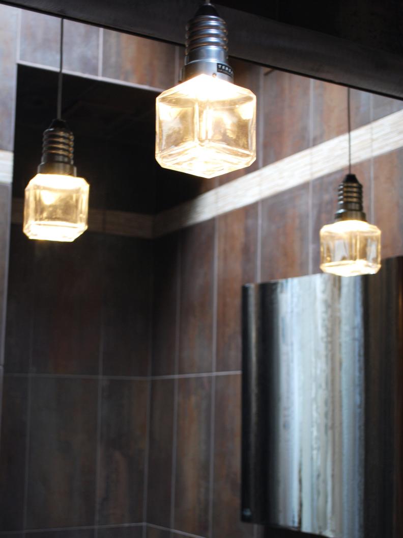 Brown Bathroom With Industrial Cube Pendants Reflecting in Mirror