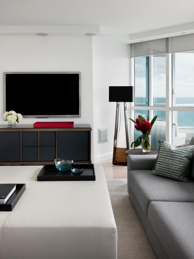 White Living Room With Gray Media Cabinet, Gray Sofa & White Ottoman