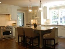 White Kitchen With Island Seating and Glass Pendant Lights 