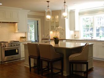White Kitchen With Island Seating and Glass Pendant Lights 