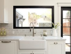 White Sink With Gray Tile Backsplash, Picture Window and White Cabinets